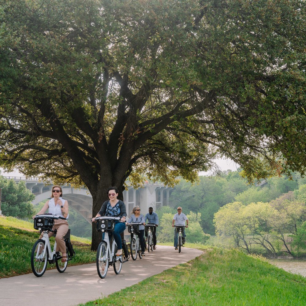 woman in white long sleeve shirt riding on bicycle during daytime